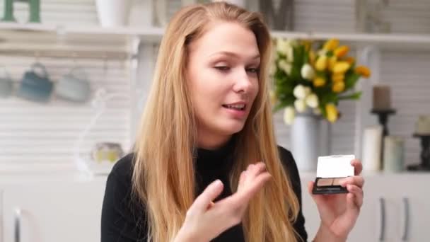 Beauty blogger vrouw filmen dagelijkse make-up routine tutorial in de buurt van de camera. Influencer meisje live streaming cosmetica product review. Vlogger vrouw beveelt oogschaduw palet, geeft les in masterclass. — Stockvideo