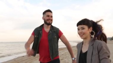 Romantik çift deniz kenarındaki beyaz kumsalda ağır çekimde el ele koşuyor. Sevgili okyanus kıyısında eğleniyor. Aşık erkek ve kadın birlikte vakit geçiriyorlar..