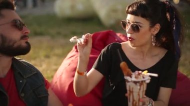 Havalı hippi çift, şehirde dondurma yiyip waffle yiyerek gülüyor. Romantik genç adam ve kadın boş vakitlerinde dışarıda dinlenirken eğleniyorlar. Kız arkadaşı erkek arkadaşını besliyor..