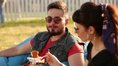 Havalı hippi çift, şehirde dondurma yiyip waffle yiyerek gülüyor. Romantik genç adam ve kadın boş vakitlerinde dışarıda dinlenirken eğleniyorlar. Kız arkadaşı erkek arkadaşını besliyor..