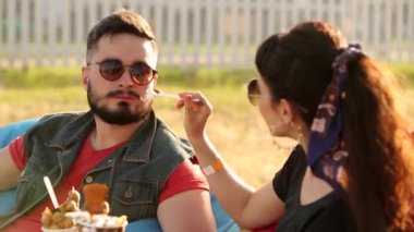 Havalı hippi çift, şehirde dondurma yiyip waffle yiyerek gülüyor. Romantik genç adam ve kadın boş vakitlerinde dışarıda dinlenirken eğleniyorlar. Kız arkadaşı erkek arkadaşını besliyor..