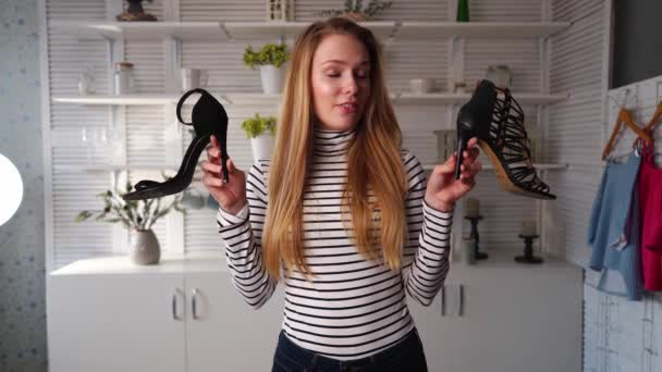 Блоггер моды в джинсах и водолазке показывает туфли на высоком каблуке на камеру. Стилист, влияющая на даму, показывает модный эпизод видеоблога обуви для своего канала. Лидер мнений устанавливает тенденции. — стоковое видео