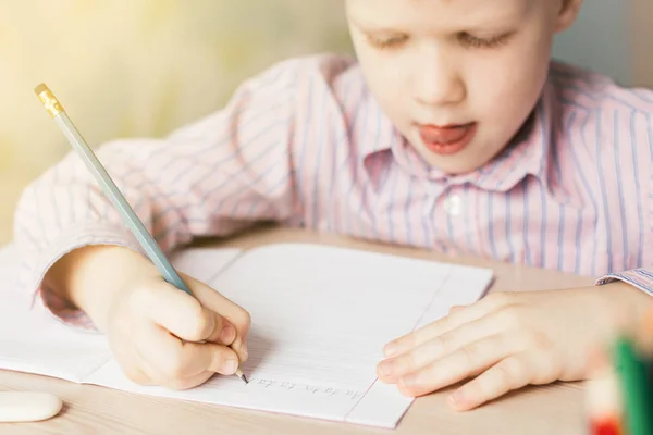 Carino bambino che scrive nel taccuino a tavola . — Foto Stock