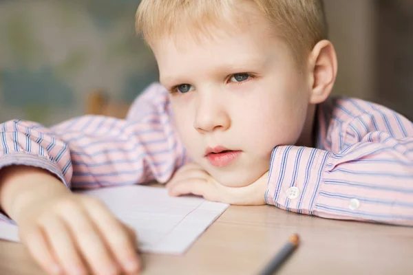 Carino ragazzo facendo la sua compiti e cercando stanco . — Foto Stock