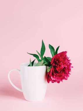 Pembe çiçek ile bir fincan.