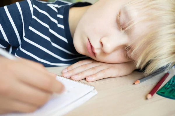 Ragazzo che dorme mentre fa i compiti nel quaderno . — Foto Stock