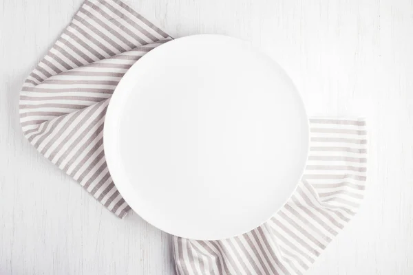 Empty white circle plate on wooden table