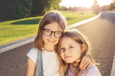 Gün batımına karşı sarılma iki neşeli kız.