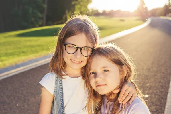 Gün batımına karşı sarılma iki neşeli kız.