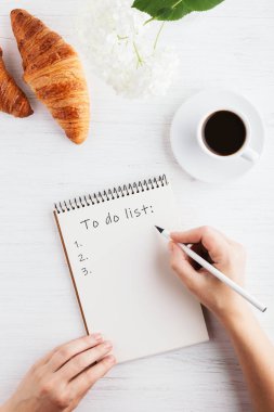 Kadının el T yapılacaklar listesi not defterinde yazısı.