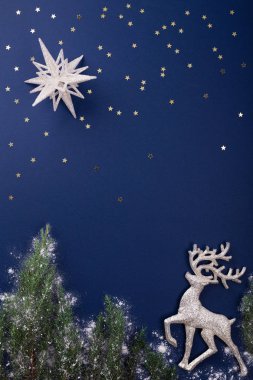 Koyu mavi zemin üzerinde ren geyiği ile Noel sahne.