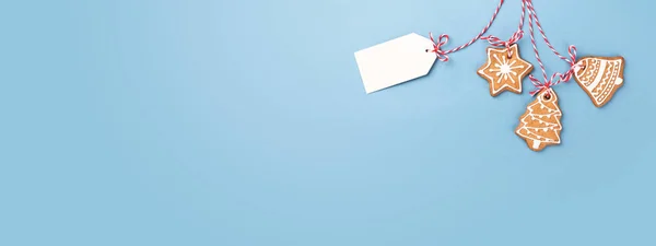 Galletas de jengibre colgando sobre fondo azul — Foto de Stock