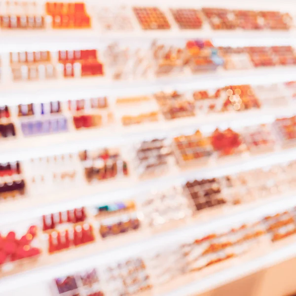 Blurred shelf with cosmetics toned in Living Coral. — Stock Photo, Image