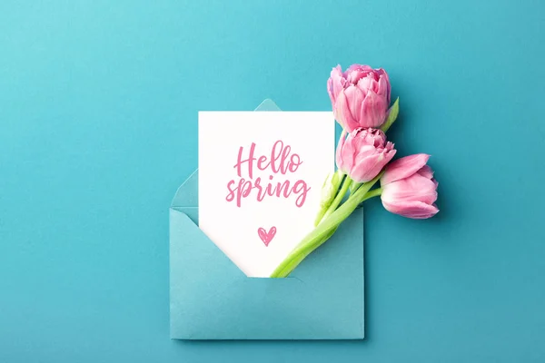 Růžové tulipány a bílá karta v obálce. — Stock fotografie