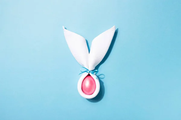 Orejas de conejo de Pascua con huevo sobre fondo azul . — Foto de Stock