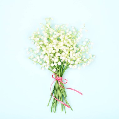 Mavi arka plan üzerinde vadi zambak buketi.