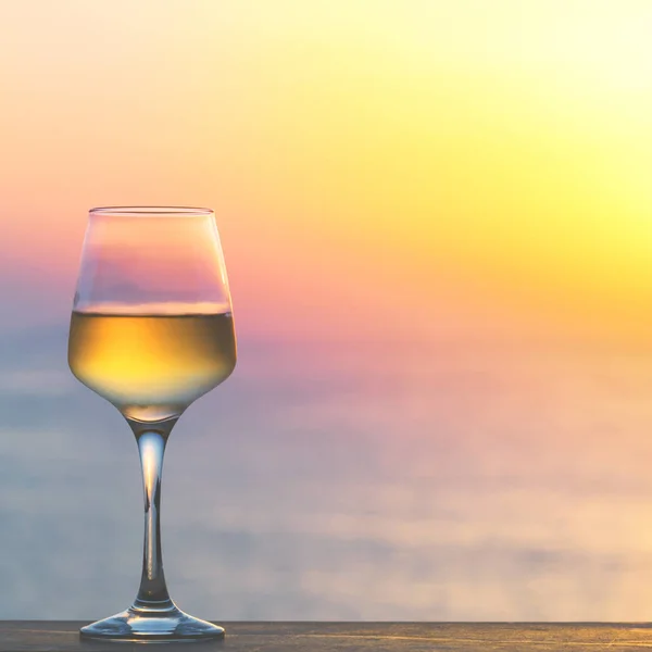 Glas Weißwein gegen den Sonnenuntergang. — Stockfoto