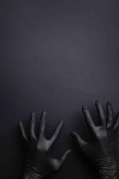 Hands in black gloves on black background. — Stock Photo, Image