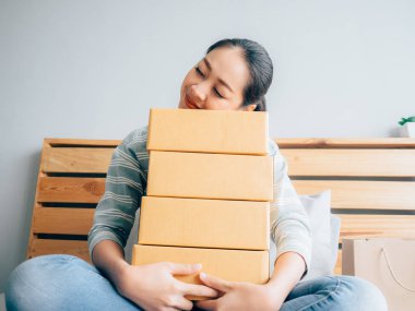 Asyalı kadın ile online iş ürünlerini mutlu hissediyor.
