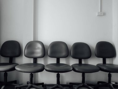 Sıra bekleyen insanlar için ofis koltukları dizi oturur.