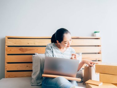 Online iş sahibi Asyalı kadın almak müşteri siparişi ve onun ürün stok kontrol.