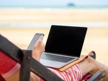 Adam sakin ol Kamp yatağı ve online Tayland Beach tatil sırasında çalışma.