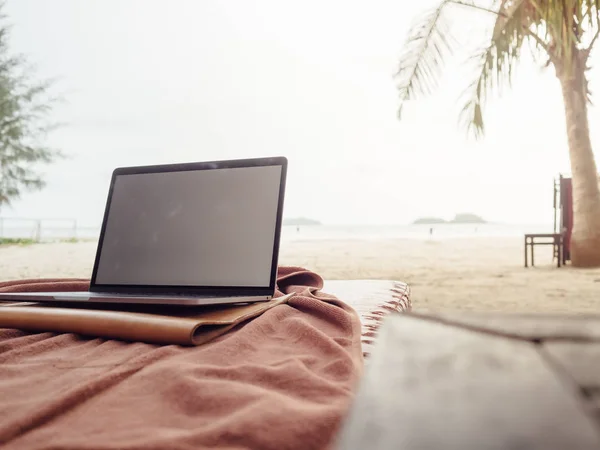 Tropikal plaj tatil sırasında dizüstü bilgisayar ile çalışma.