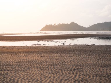 Tayland günbatımı ışığı ile sahilde dalgalı kum.
