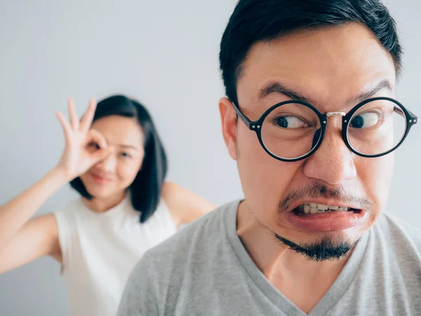 Asian angry and annoyed husband with happy and stubborn wife argument concept.