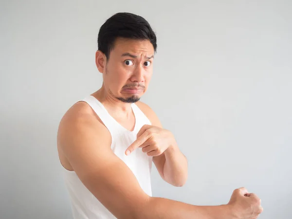 苦しい顔白いタンクトップのアジア人男性が腕に日焼けを得る — ストック写真