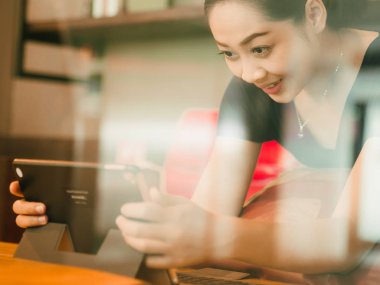 Asyalı kadın kahvesini kafede ile rahatlayın. Windows camdan ateş.