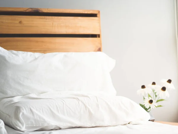 朝の光で花を持つ最小限のロフト スタイル木製ベッドのヘッドボード — ストック写真