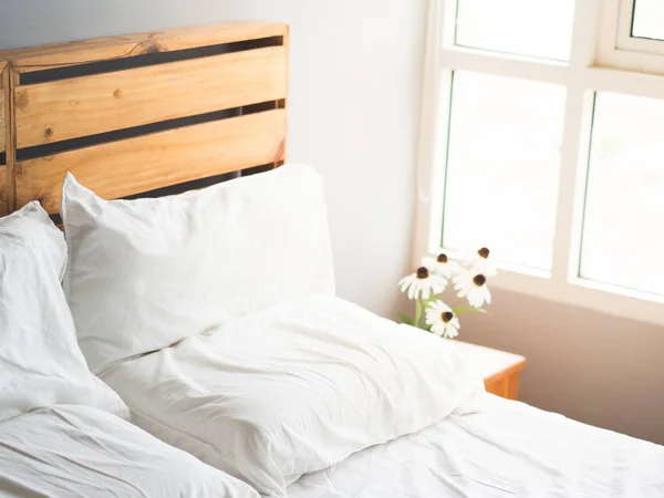 朝の光で花を持つ最小限のロフト スタイル木製ベッドのヘッドボード — ストック写真