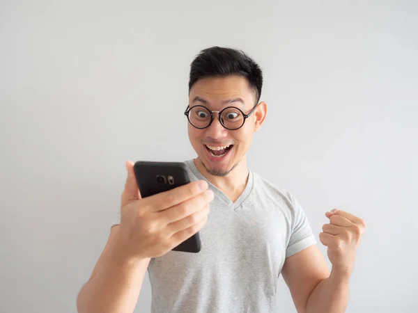 Asya adam ne smartphone izole gri arka plan üzerinde görmekten mutlu.