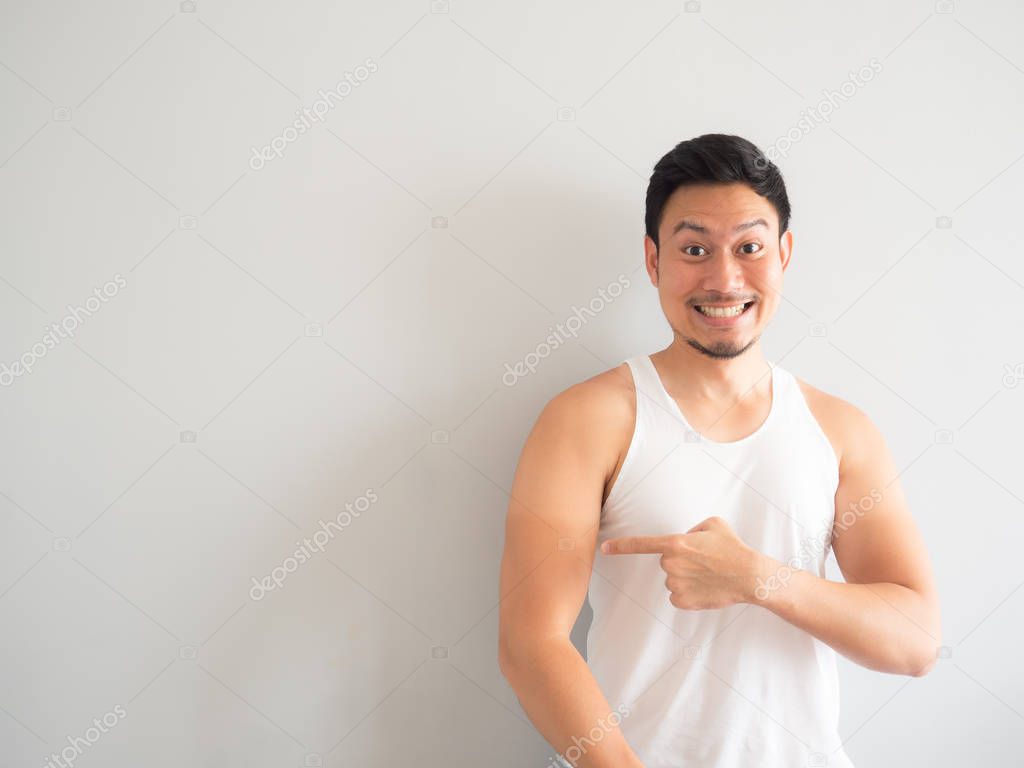 Happy face Asian man in white tank top get tanned on the arm.