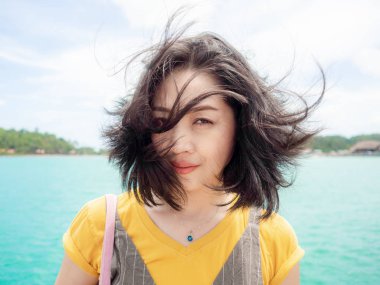 Asyalı kadın portre fotoğraf deniz ve ada arkasında ile rüzgarlı Beach.