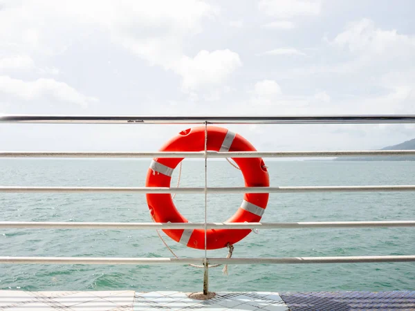 Red life ring is hanging on the ferry.