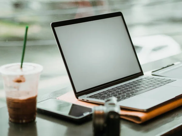 Boş ekran laptop kamera ve buz kahve kafede. Serbest çalışma kavramı.
