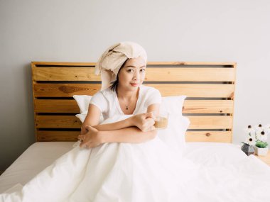 Mutlu Asyalı kadın duş sonra sabah kahve içmek.