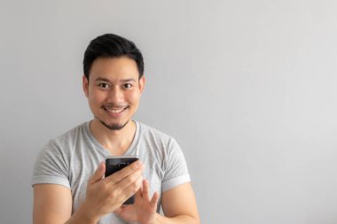 Gülümseme ve Asya adamın mutlu yüzünü kullanın ve onun smartphone dokunmatik.