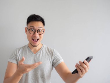 Asya adam ne smartphone izole gri arka plan üzerinde görmekten mutlu.