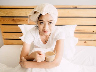 Mutlu Asyalı kadın duş sonra sabah kahve içmek.