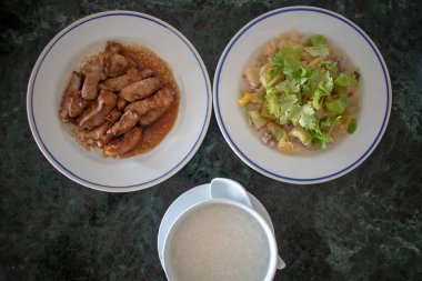 İki yan yemekler ile Tay yulaf lapası kahvaltı seti üstten görünüm.