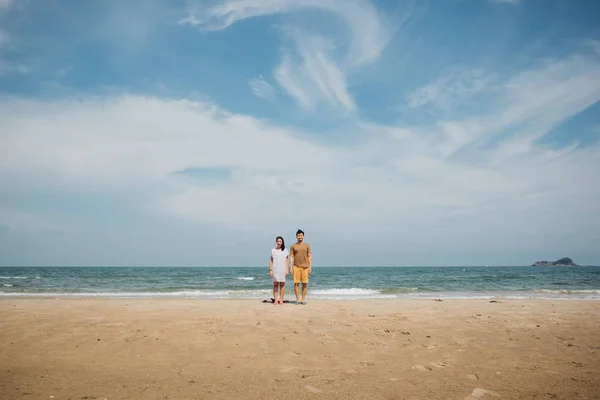 Couple asian couple stand for taking a minimal photograph of the beach.