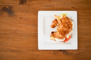 Peynir jambon kruvasan masada beyaz tabak.