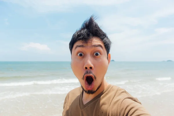 Wow and surprised face of asian man selfie himself on the beach of Thailand.