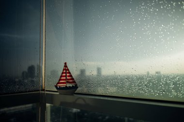 Biraz güneş ışığı ile yağmurlu windows kenarına küçük Yelkenli.