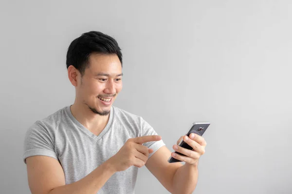 Smile and happy face of Asian man use and touch his smartphone.