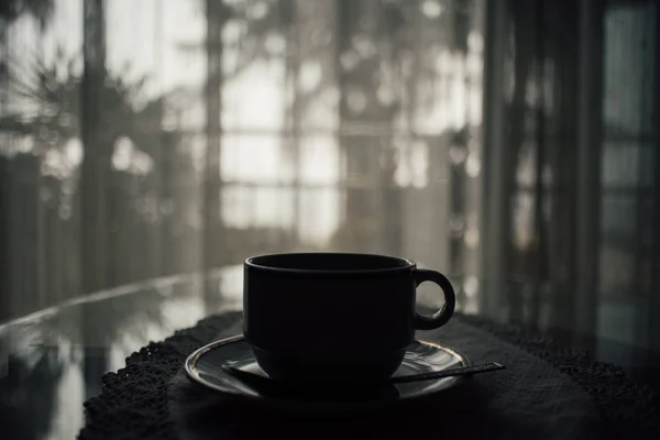 在房子的桌子上的热咖啡杯剪影 — 图库照片