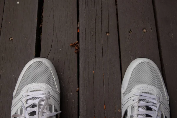 木の床に白いランニング シューズ 運動のコンセプト — ストック写真